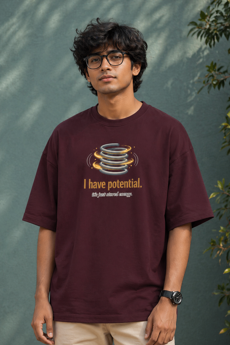 Person wearing a maroon t-shirt with a graphic and text against a green background