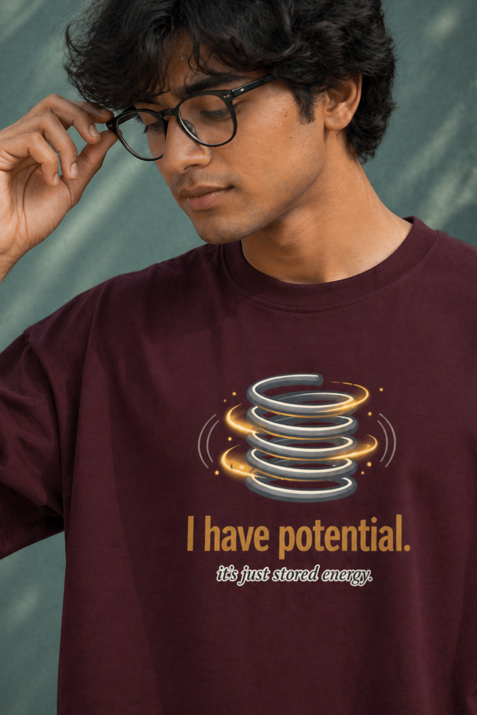 Person wearing a maroon t-shirt with a motivational quote and spiral design.