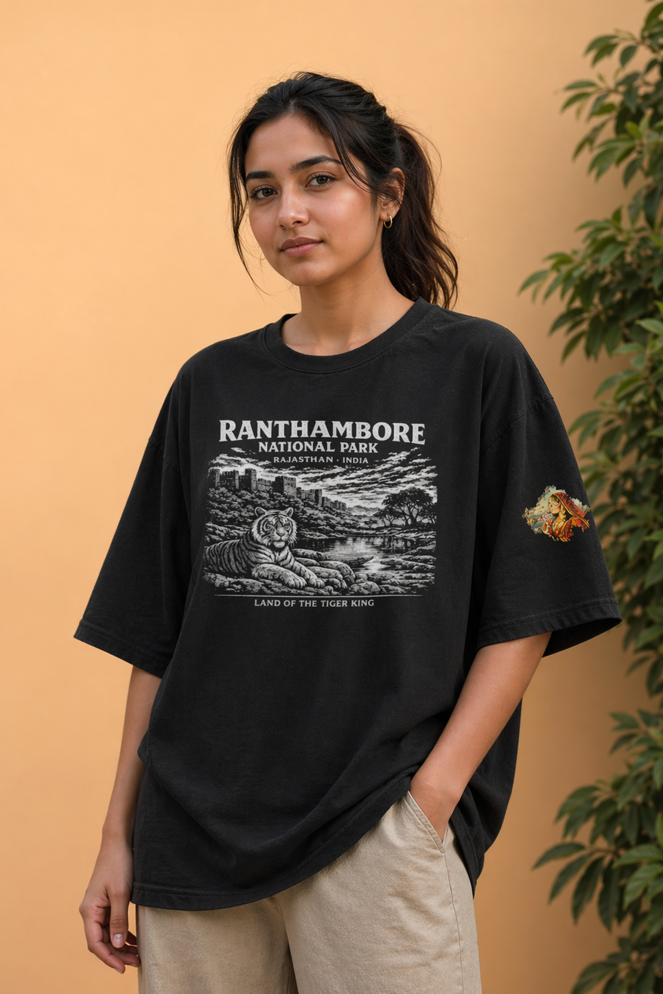 Person wearing a black t-shirt with Ranthambore National Park design against a beige background
