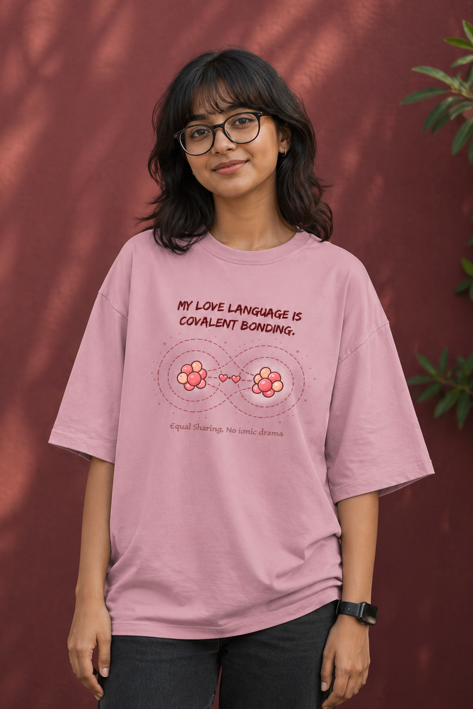 Person wearing a pink t-shirt with a graphic and text against a red background